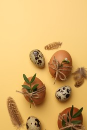 Festively decorated eggs on yellow background, flat lay. Happy Easter