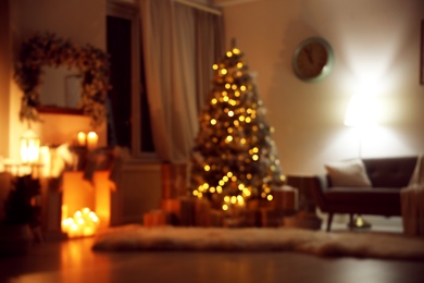 Blurred view of festive interior with Christmas tree and decorative fireplace