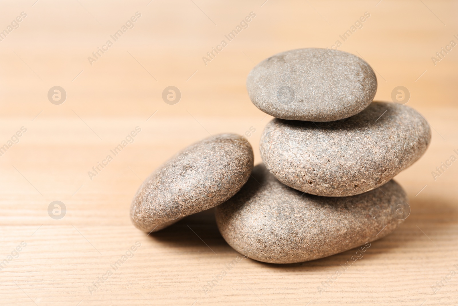 Photo of Stack of spa stones on wooden table. Space for text