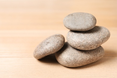 Stack of spa stones on wooden table. Space for text