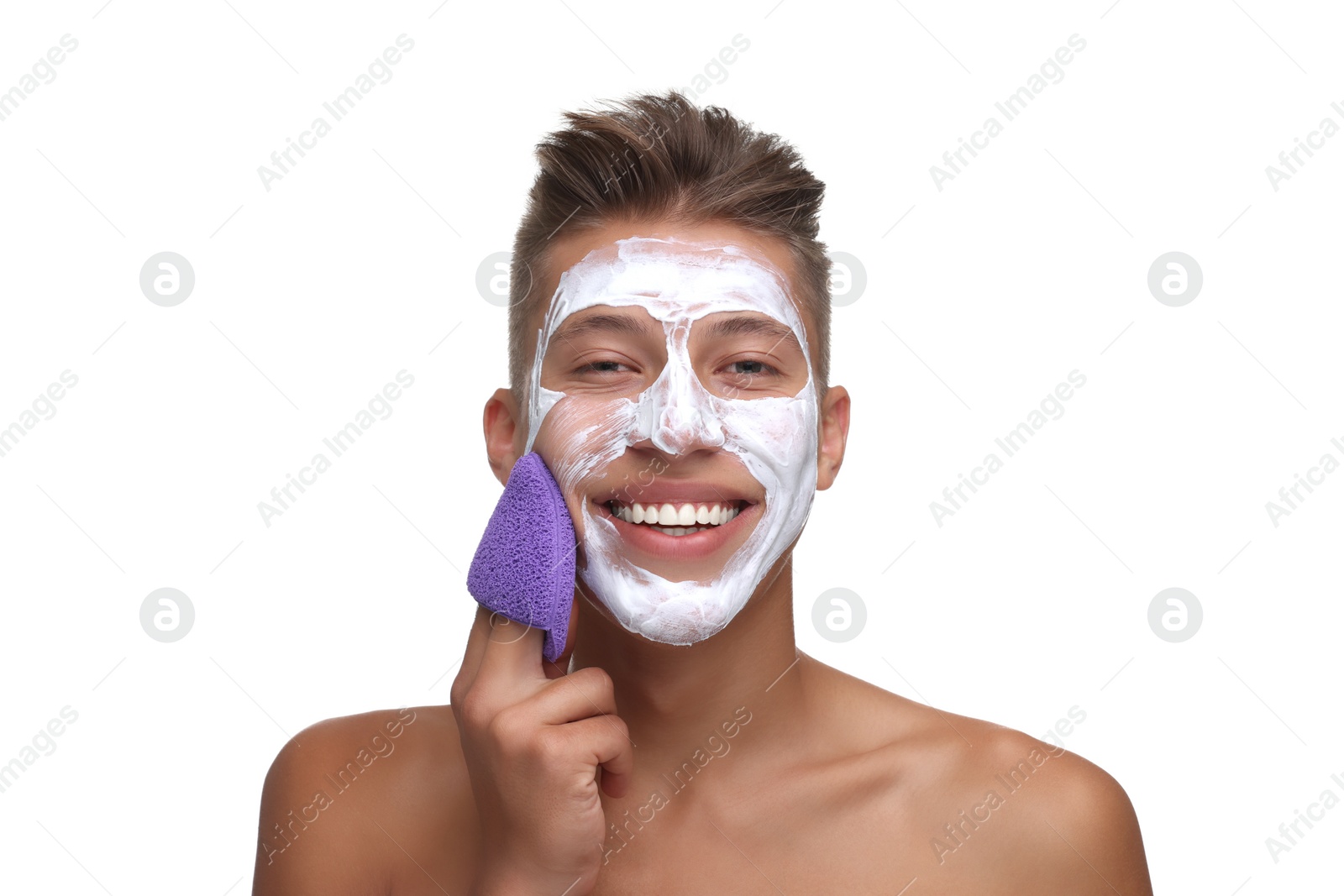 Photo of Happy young man washing off face mask with sponge on white background