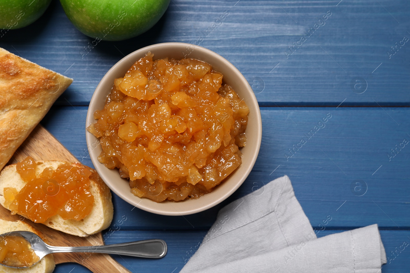 Photo of Flat lay composition with delicious apple jam on blue wooden table, space for text