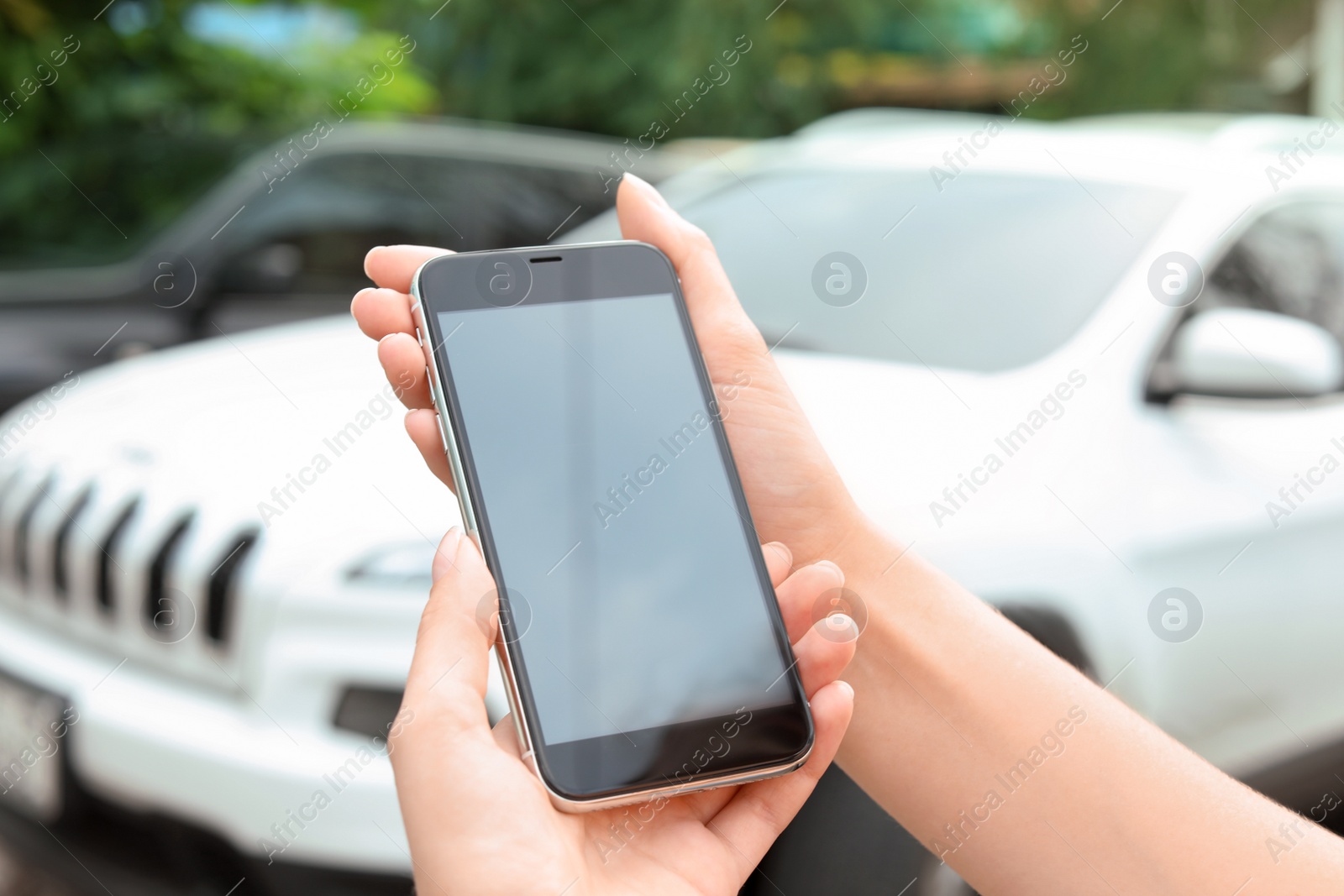 Photo of Woman holding modern smartphone outdoors. Mock up with space for text