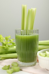 Photo of Glass of celery juice and fresh vegetables on table