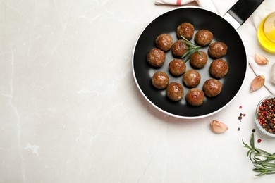 Photo of Tasty cooked meatballs on light grey marble table, flat lay. Space for text