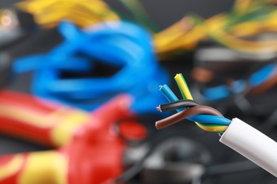 Photo of One new colorful electrical wire on blurred background, closeup view