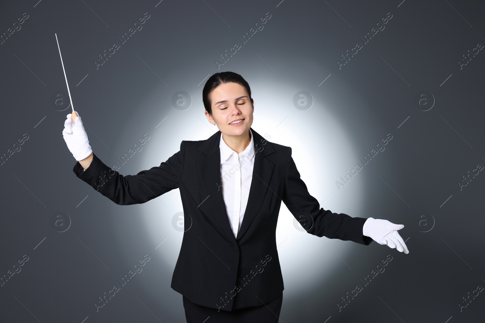 Photo of Professional conductor with baton on grey background