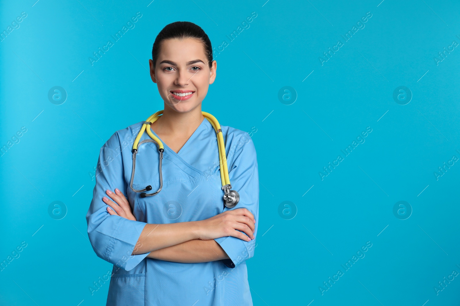 Photo of Portrait of young medical assistant with stethoscope on color background. Space for text