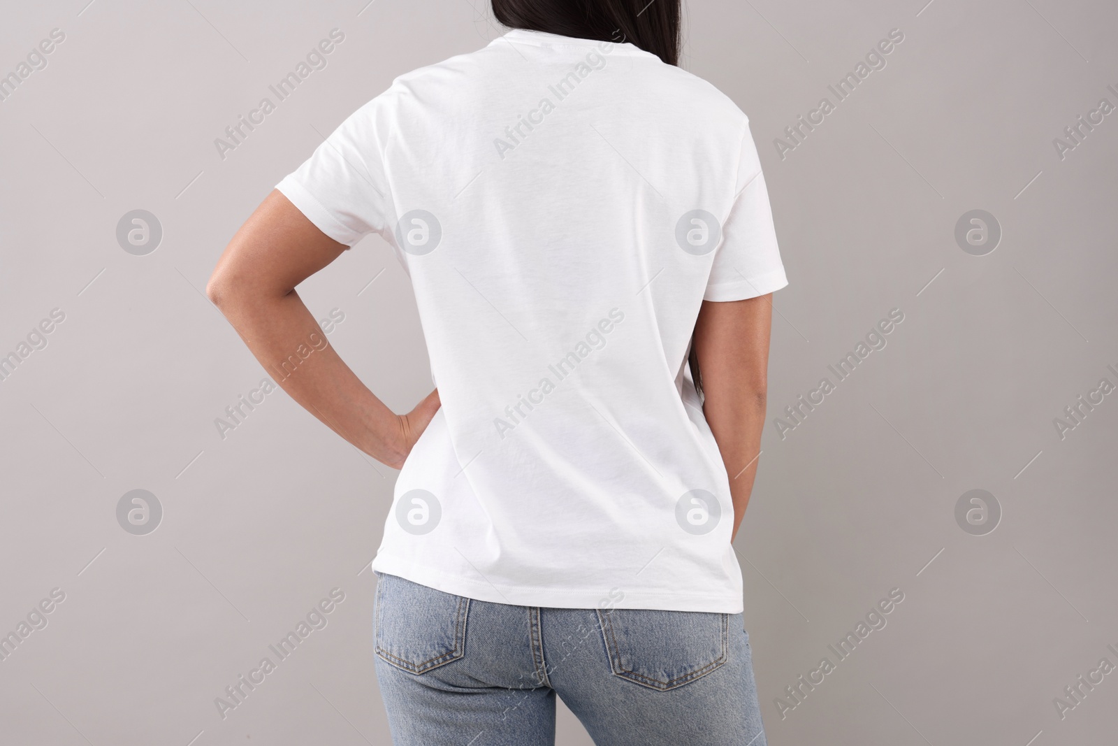 Photo of Woman wearing white t-shirt on light grey background, closeup