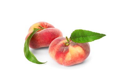 Photo of Fresh ripe donut peaches with leaves on white background