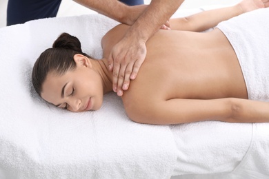 Relaxed woman receiving back massage in wellness center