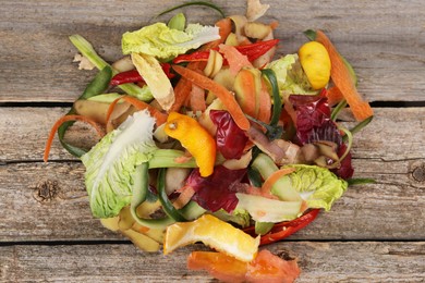 Peels of fresh vegetables on wooden table, top view