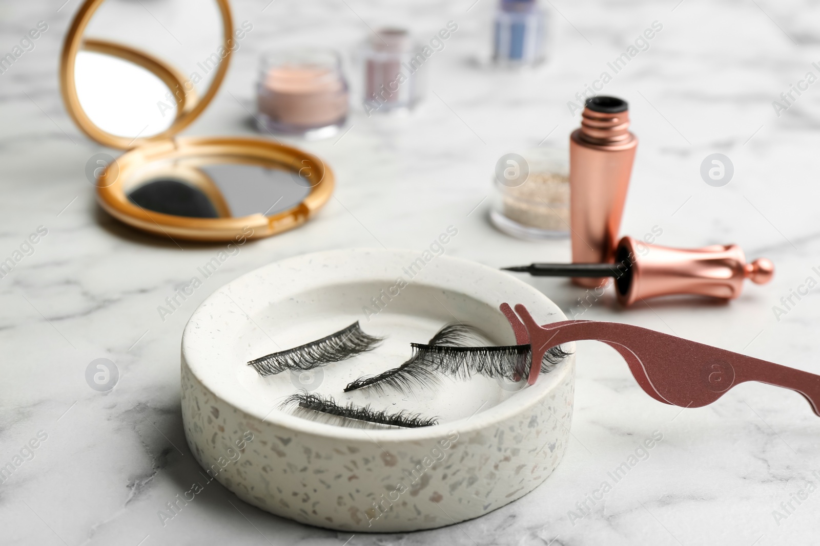 Photo of Magnetic eyelashes and accessories on white marble table