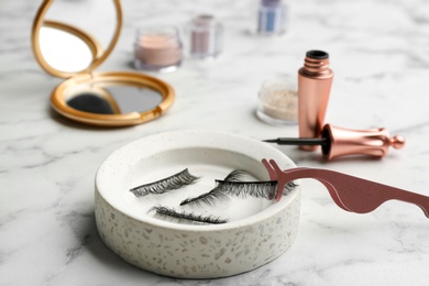 Magnetic eyelashes and accessories on white marble table