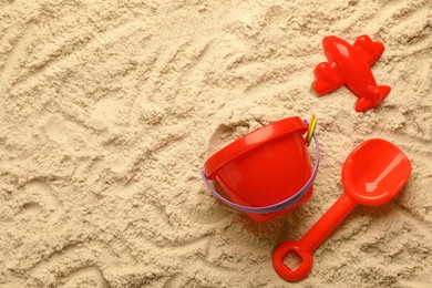 Flat lay of beach toy kit on sand, space for text. Outdoor play