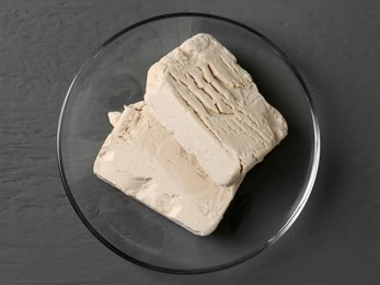 Photo of Compressed yeast on grey wooden table, top view