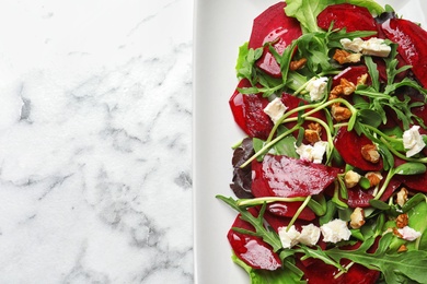 Photo of Plate with delicious beet salad on marble background, top view