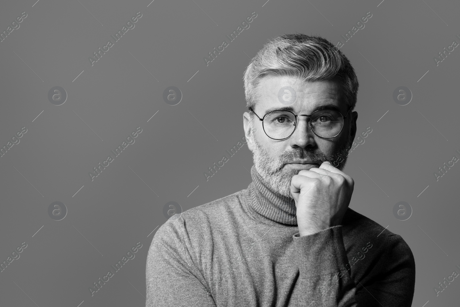 Photo of Portrait of handsome man on grey background, space for text. Black and white effect