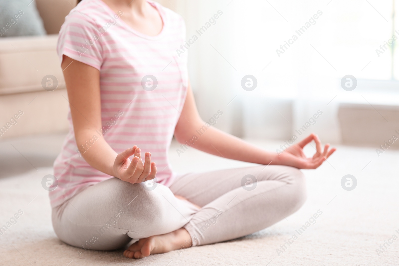 Photo of Young woman meditating on floor at home, closeup. Zen concept