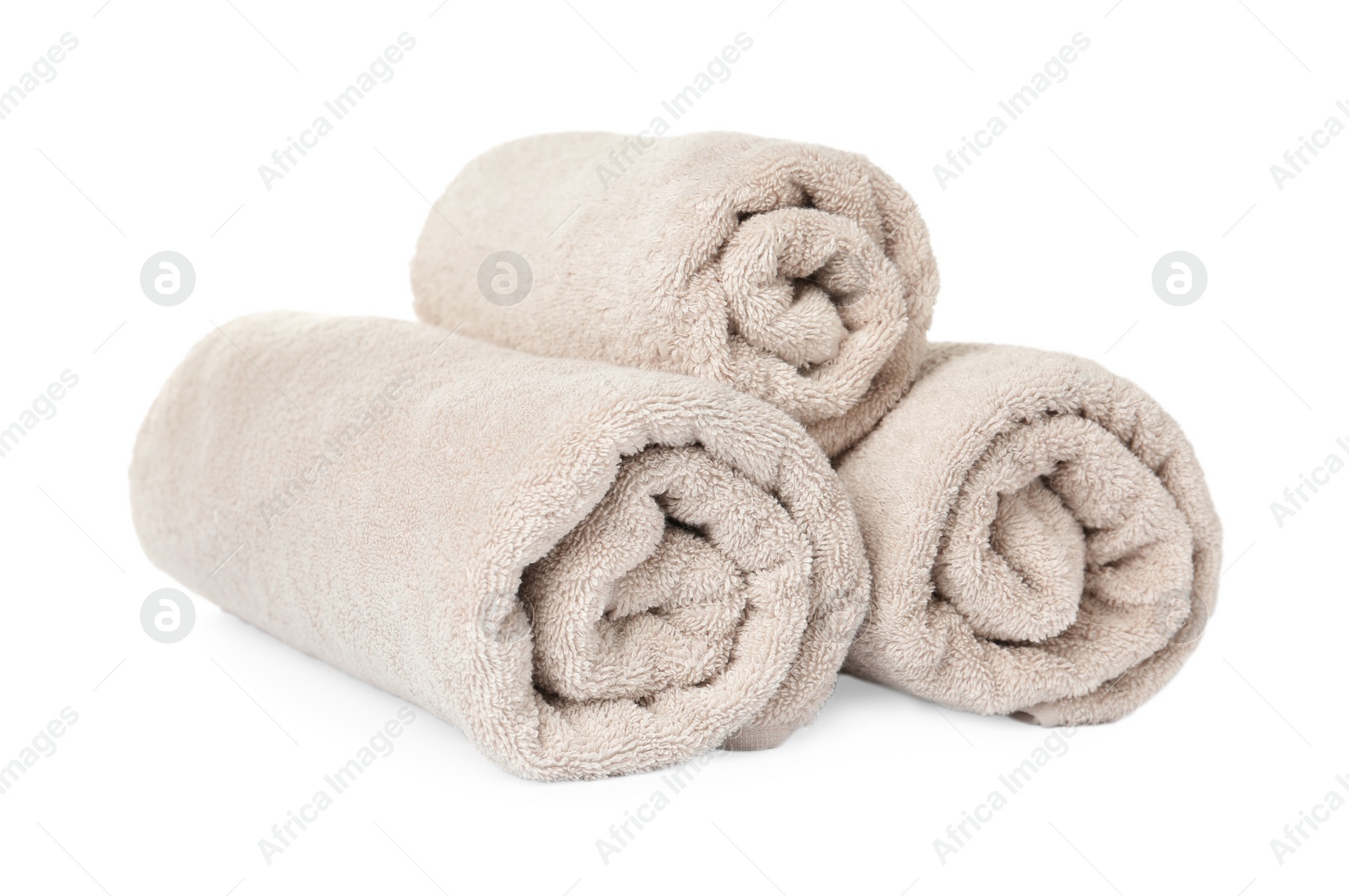 Photo of Rolled clean beige towels on white background