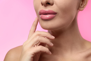 Photo of Woman with glossy lipstick on pink background, closeup