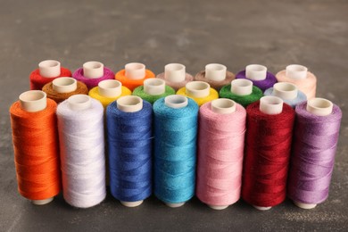Photo of Set of color sewing threads on grey table