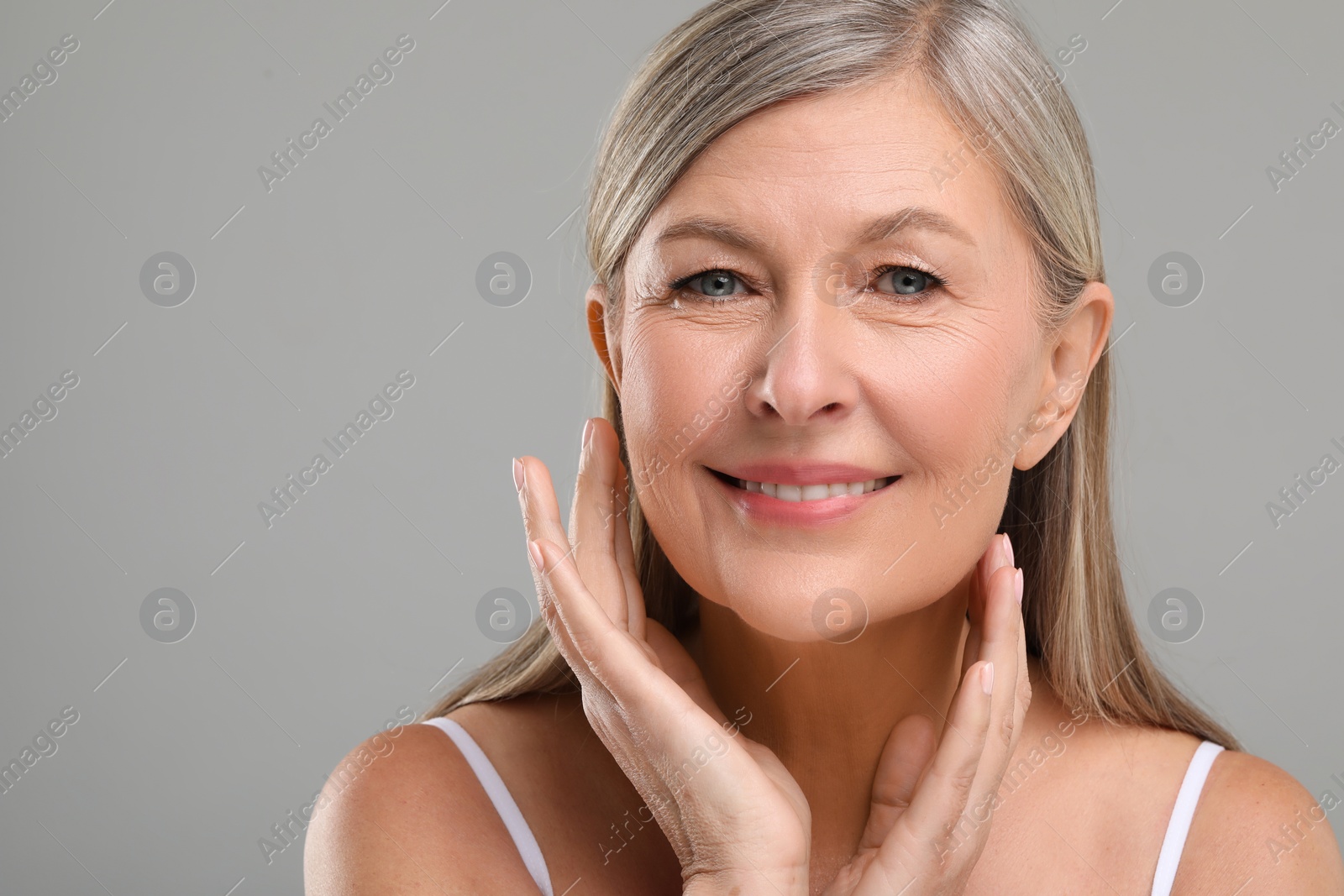 Photo of Beautiful mature woman with healthy skin on gray background, space for text