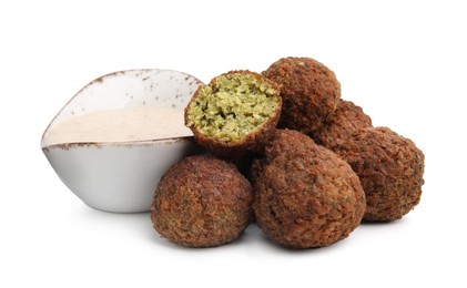 Photo of Delicious falafel balls and sauce isolated on white