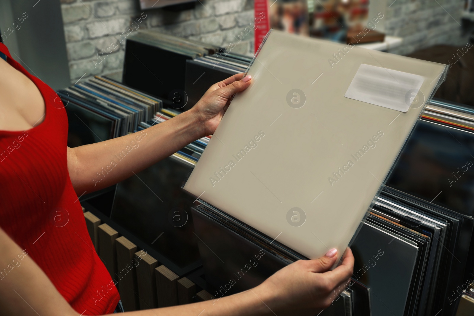 Image of Woman with vinyl record in store, closeup