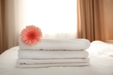Photo of Flower on stack of fresh towels in hotel room