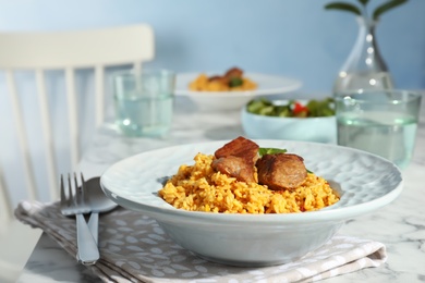 Plate with delicious rice pilaf served on table