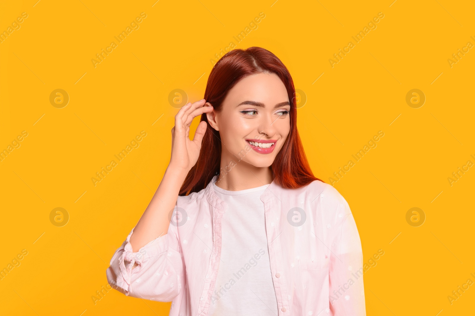 Photo of Happy woman with red dyed hair on orange background