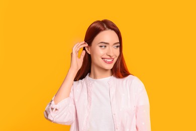 Photo of Happy woman with red dyed hair on orange background