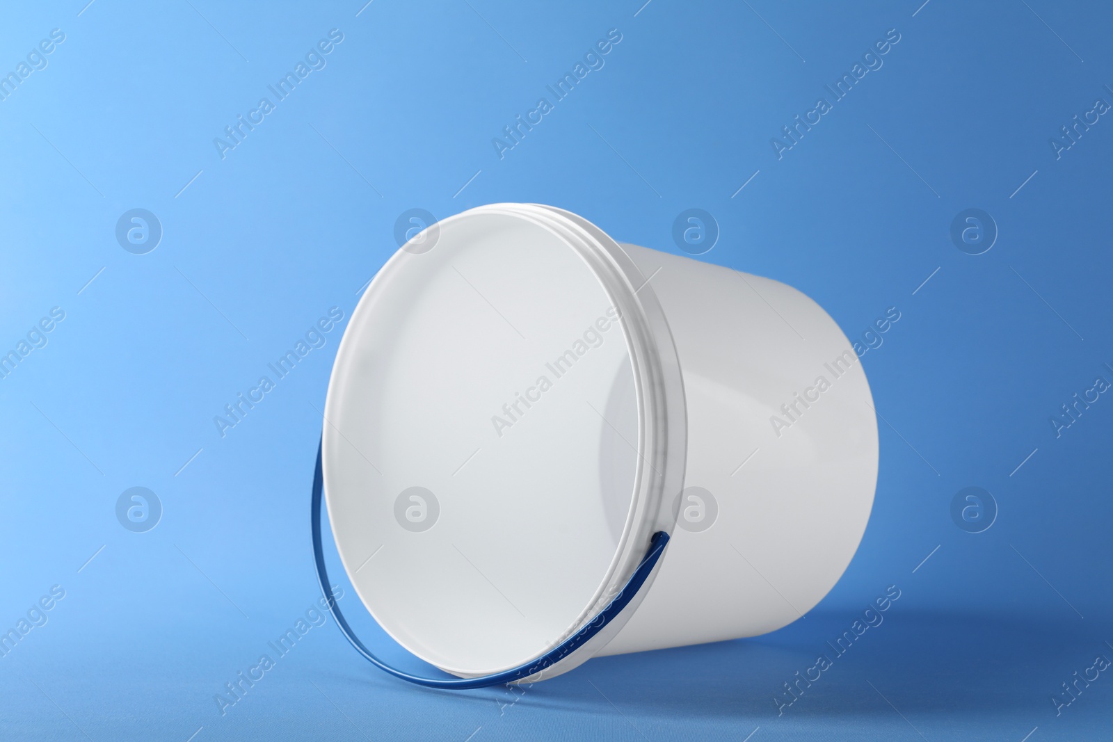 Photo of One empty plastic bucket on light blue background