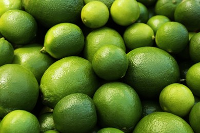 Photo of Fresh ripe green limes as background, closeup