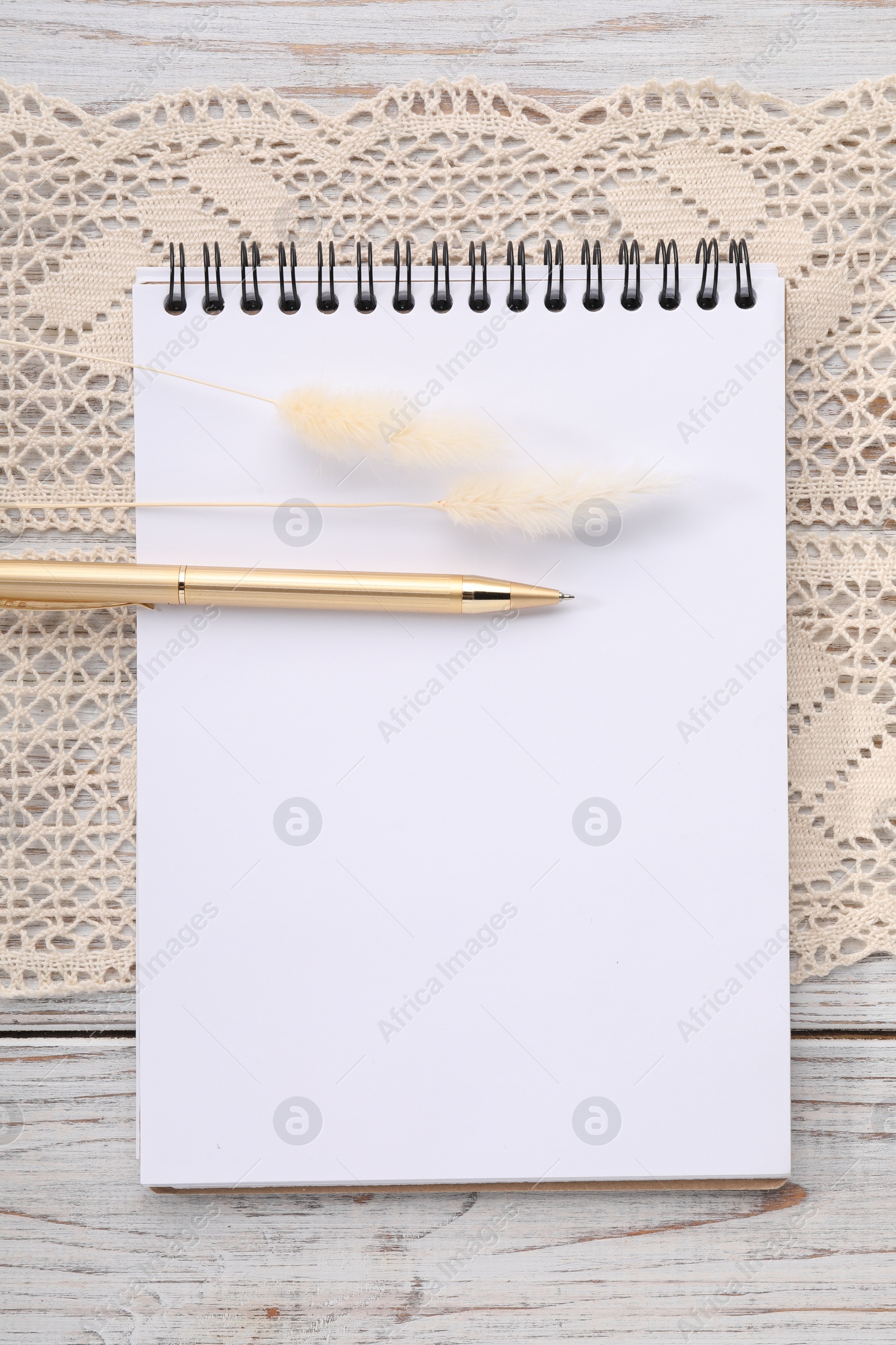 Photo of Guest list. Notebook, pen, spikelets and lace ribbon on wooden background, flat lay