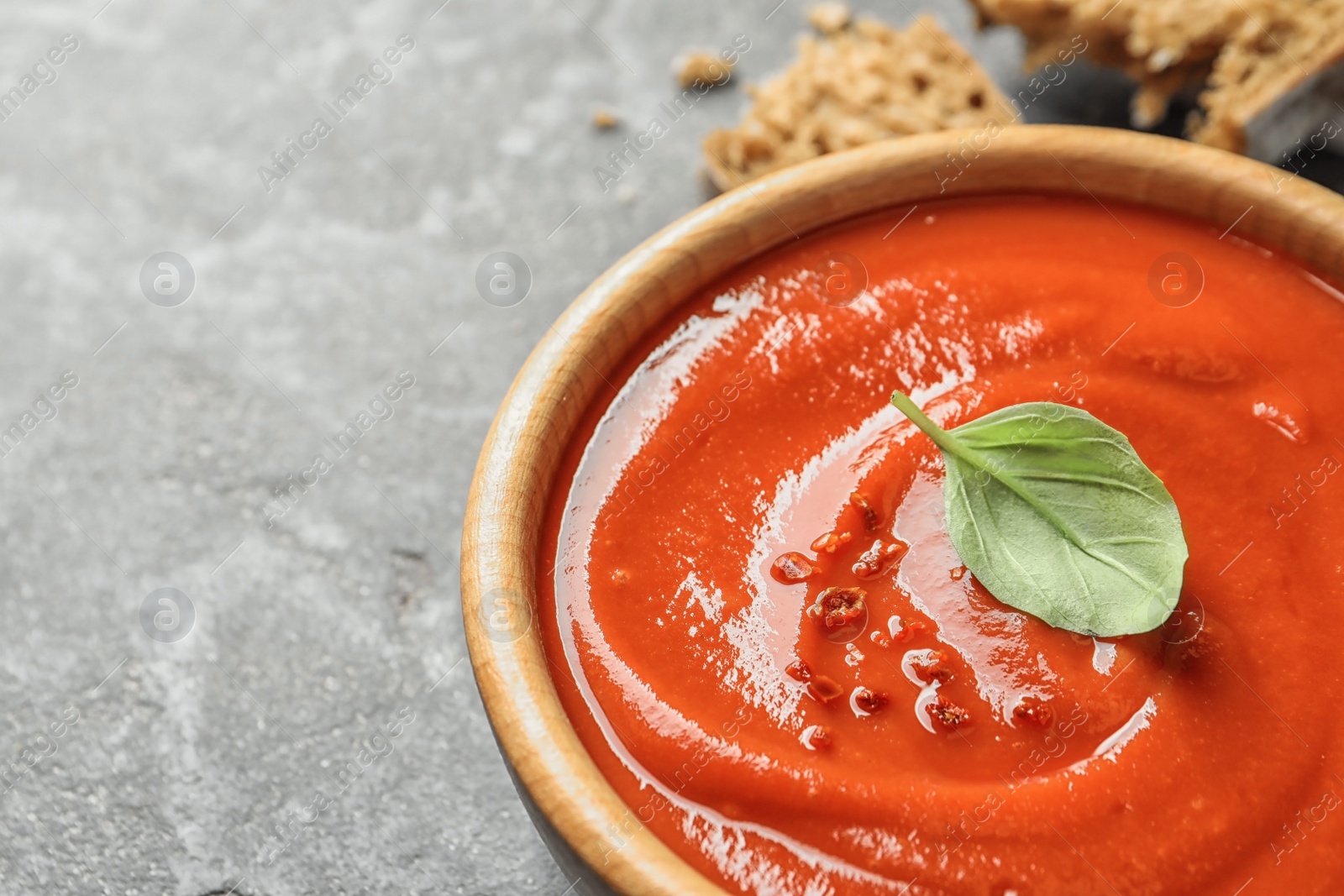 Photo of Bowl with fresh homemade tomato soup on table, closeup. Space for text