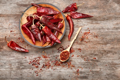 Composition with dry chili peppers and flakes on wooden background