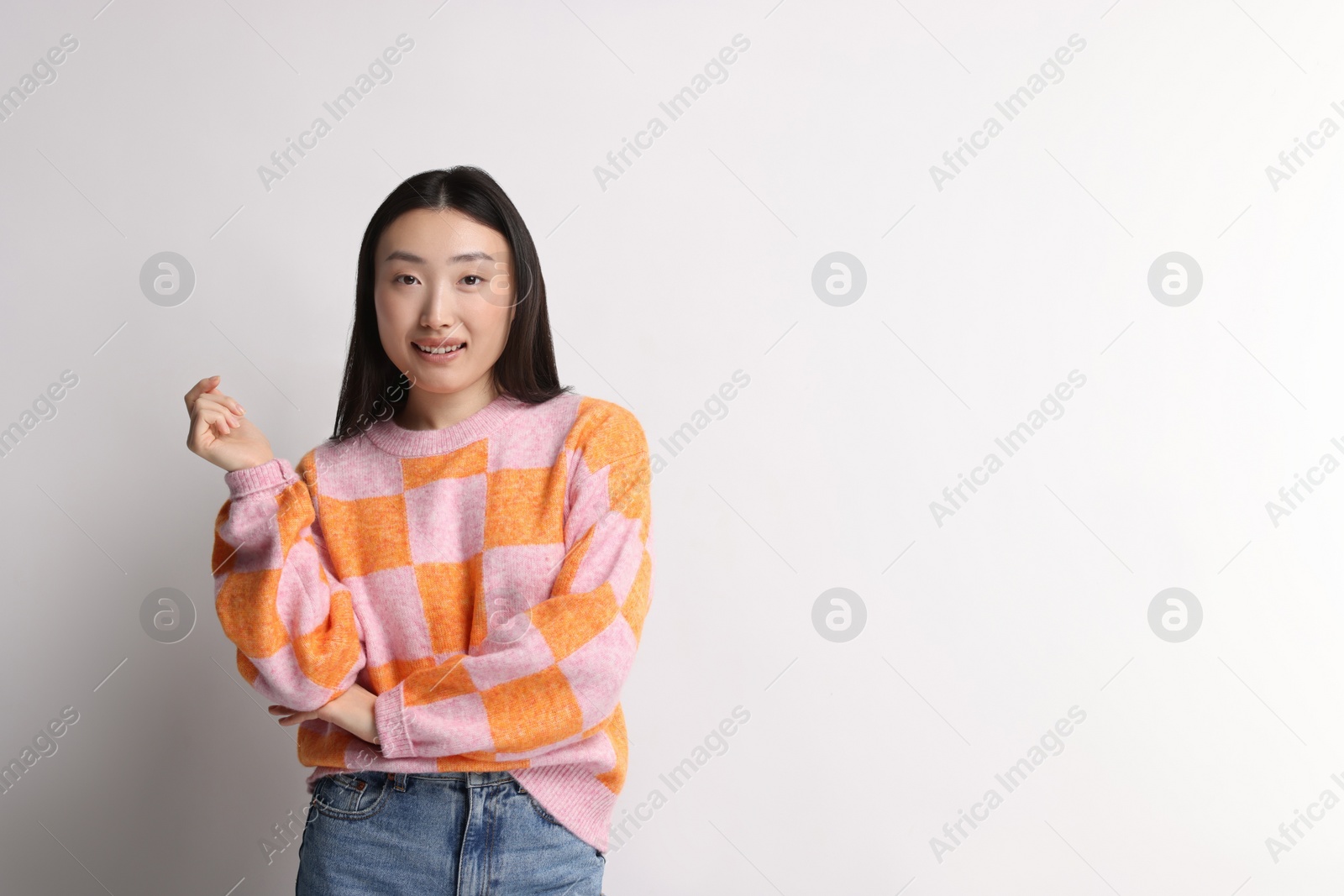 Photo of Portrait of smiling woman on light background. Space for text