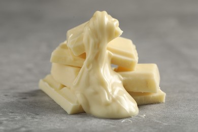 Pieces of white chocolate and tasty paste on grey table, closeup