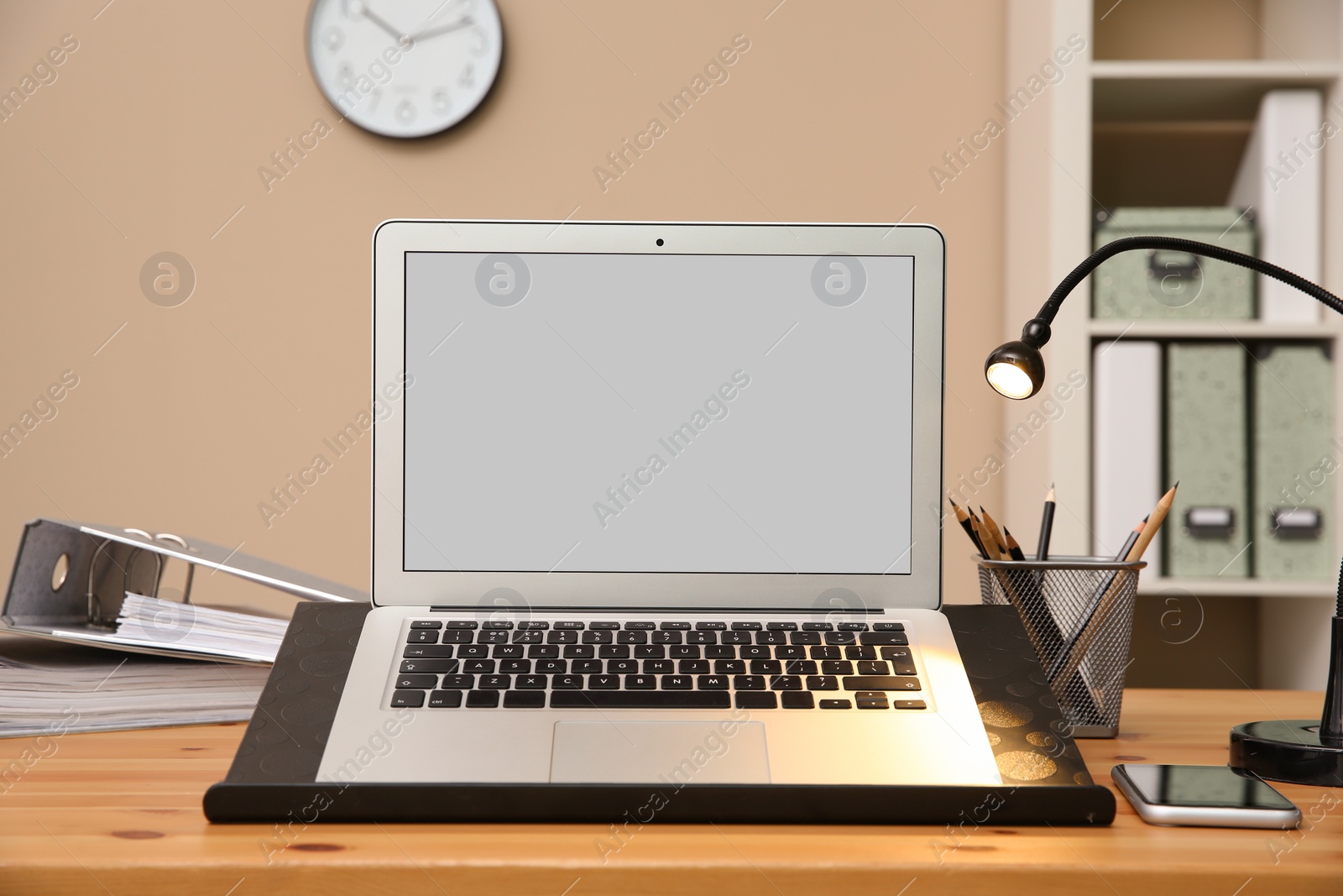 Photo of Stylish workplace with modern laptop on desk
