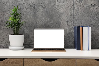 Workplace with modern laptop on white table. Mockup for design