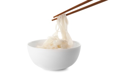 Taking rice noodles with chopsticks from bowl on white background