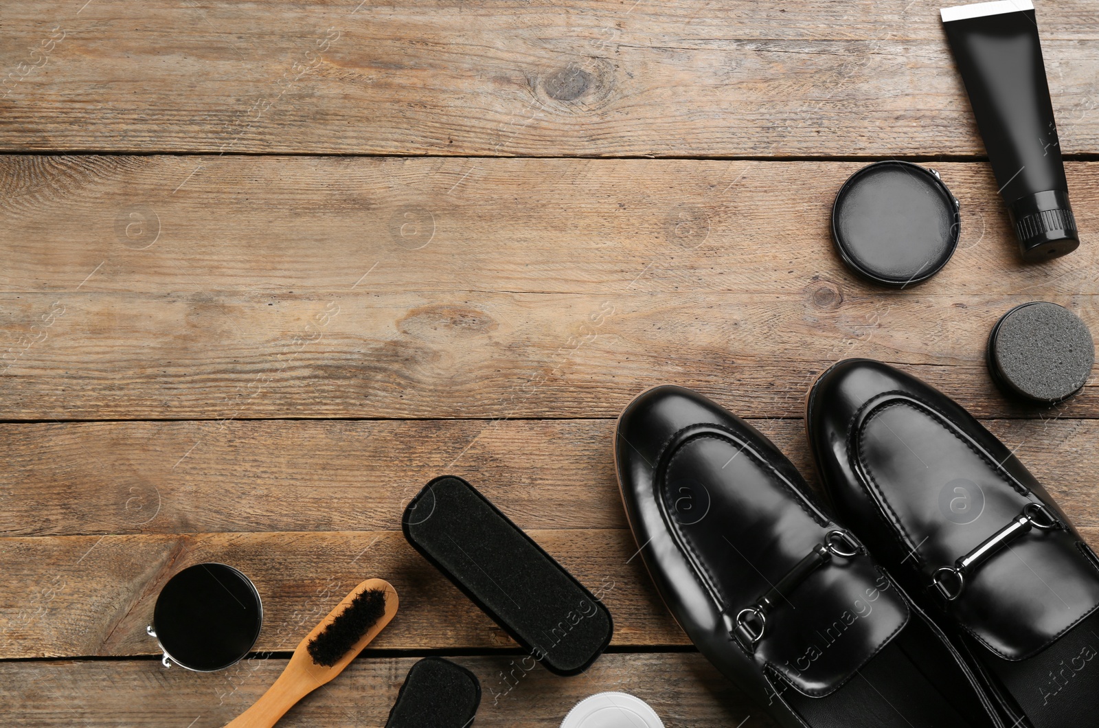 Photo of Flat lay composition with shoe care accessories and footwear on wooden background. Space for text