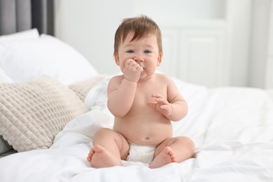 Photo of Cute baby boy sitting on bed at home