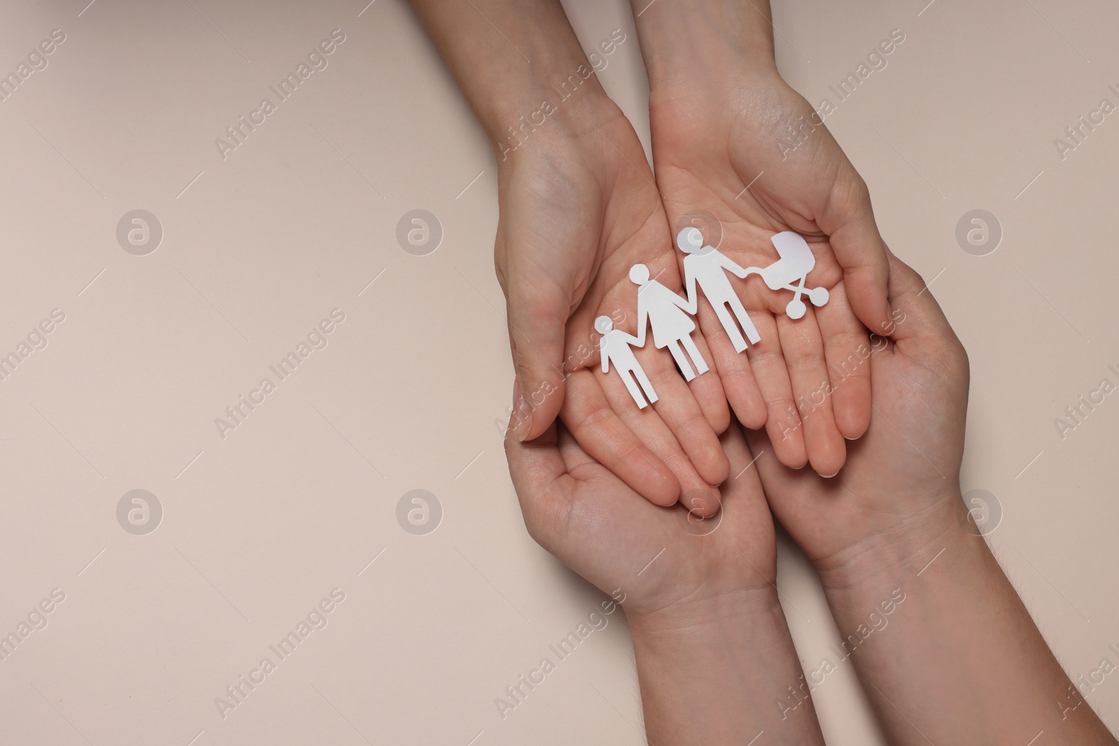 Photo of Couple holding paper family figures on beige background, top view with space for text. Insurance concept