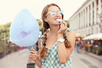 Photo of Young woman with cotton candy on city street