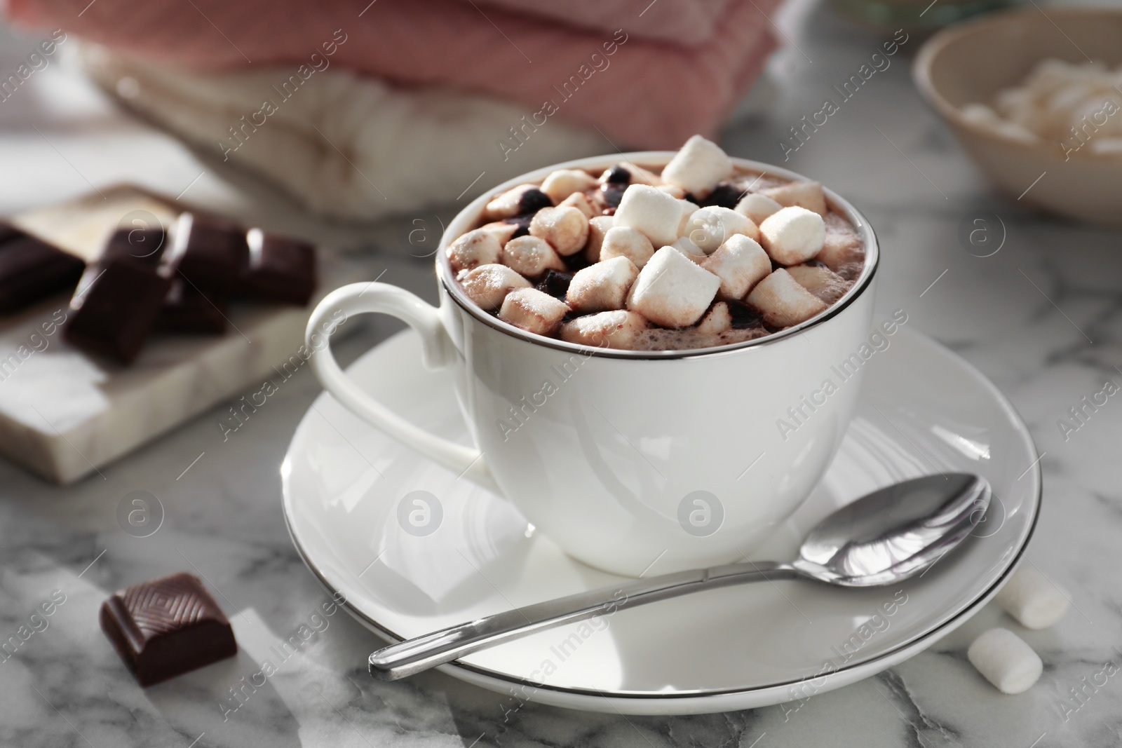 Photo of Cup of aromatic hot chocolate with marshmallows served on light marble table, closeup