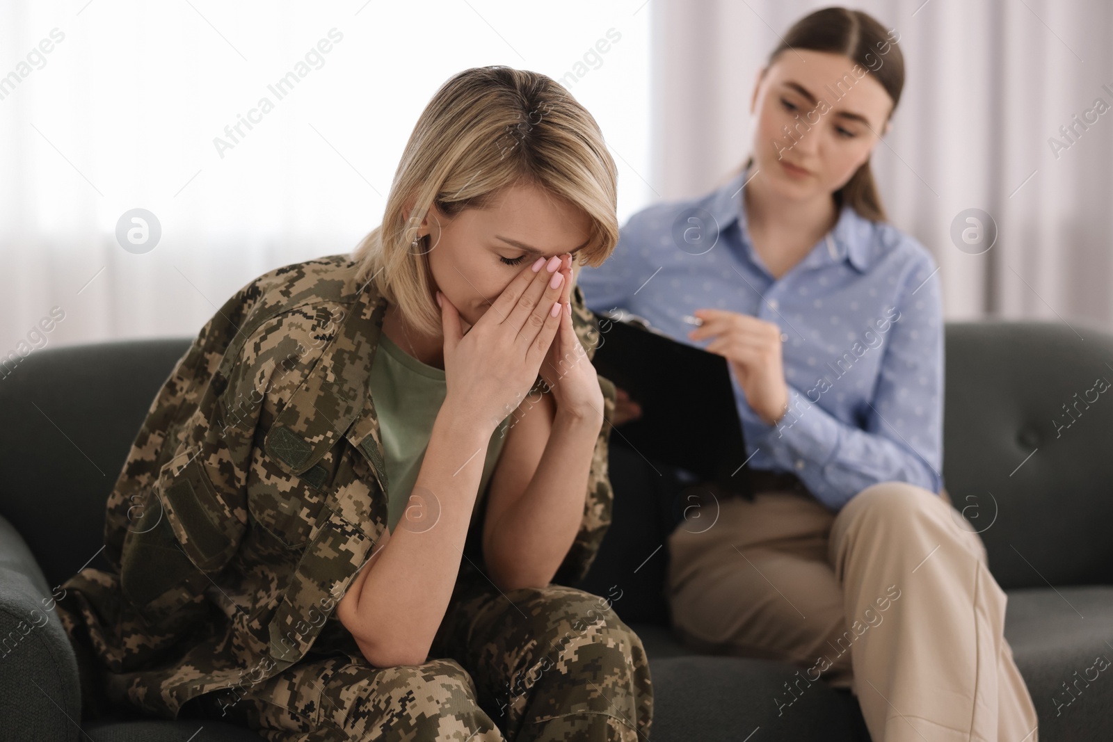 Photo of Psychotherapist working with military woman on sofa in office