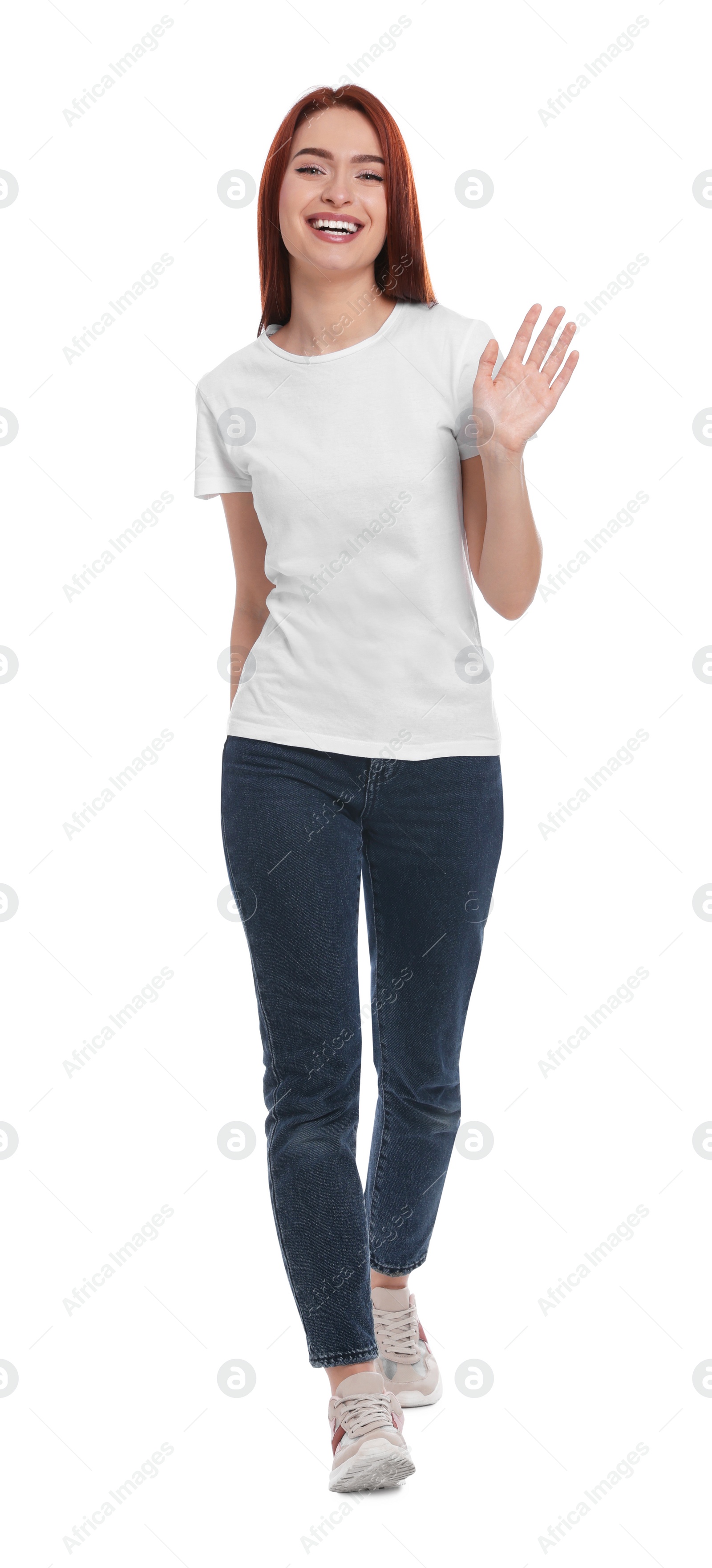 Photo of Happy woman with red dyed hair walking and showing greeting gesture on white background